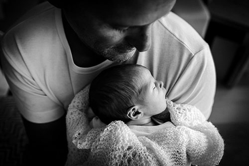 Close up of dad holding new born baby