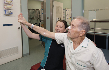 Man participating in rehabilitation therapy with help of physiotherapist